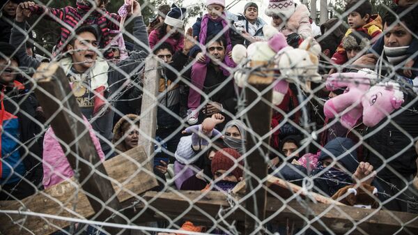 Des migrants protestent derrière une clôture contre les restrictions limitant le passage à la frontière gréco-macédonienne, près de Gevgelija, le 1er décembre 2015. Depuis la semaine dernière, la Macédoine limite le passage vers le nord de l'Europe aux seuls Syriens, Irakiens et Afghans qui sont considérés comme des réfugiés de guerre. Toutes les autres nationalités sont considérées comme des migrants économiques et priées de faire demi-tour. Le 29 novembre, la Macédoine a terminé la construction d'une clôture à sa frontière avec la Grèce, devenant ainsi le dernier pays d'Europe à construire une barrière frontalière visant à contrôler le flux de migrants. - Sputnik Afrique