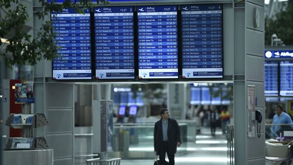 A passengers walks under information boards at the airport in Duesseldorf, Germany - Sputnik Afrique
