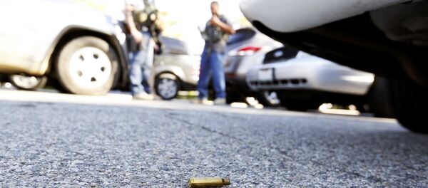 A spent cartrdige lies on the ground as police officers secure the area after at least one person opened fire at a social services agency in San Bernardino. - Sputnik Afrique