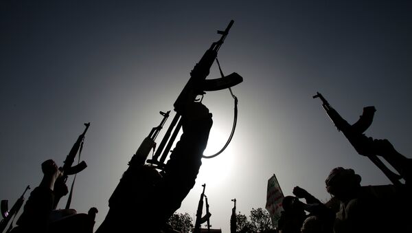 Shiite rebels known as Houthis hold up their weapons to denounce the Saudi-led airstrikes as they chant slogans during a protest in Sanaa, Yemen - Sputnik Afrique