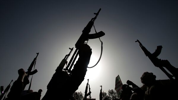 Les rebelles chiites connus sous le nom de Houthis brandissent leurs armes pour dénoncer les frappes aériennes menées par l'Arabie saoudite alors qu'ils scandent des slogans lors d'une manifestation à Sanaa, au Yémen. - Sputnik Afrique