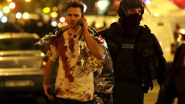 Un policier français assiste une victime près de la salle de concert du Bataclan à Paris, en novembre 2015 - Sputnik Afrique