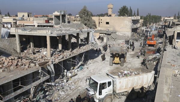 Les résidents inspectent les dommages sur un site touché par l'un des trois camions explosifs dans la ville syrienne de Tel Tamer - Sputnik Afrique