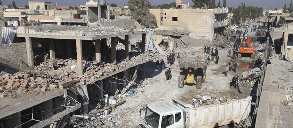 Les résidents inspectent les dommages sur un site touché par l'un des trois camions explosifs dans la ville syrienne de Tel Tamer - Sputnik Afrique