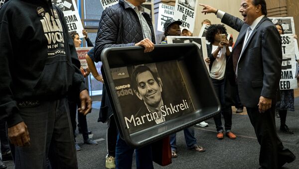Un manifestant tenant un portrait de Martin Shkreli - Sputnik Afrique