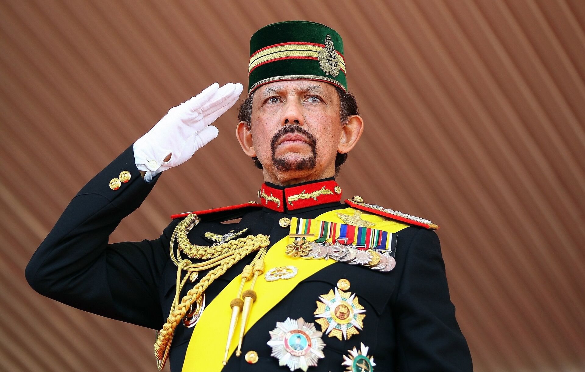 Brunei's Sultan Hassanal Bolkiah salutes during a ceremonial guard of honour to mark his 68th birthday celebrations in Bandar Seri Begawan on August 14, 2014. - Sputnik Afrique, 1920, 19.11.2023