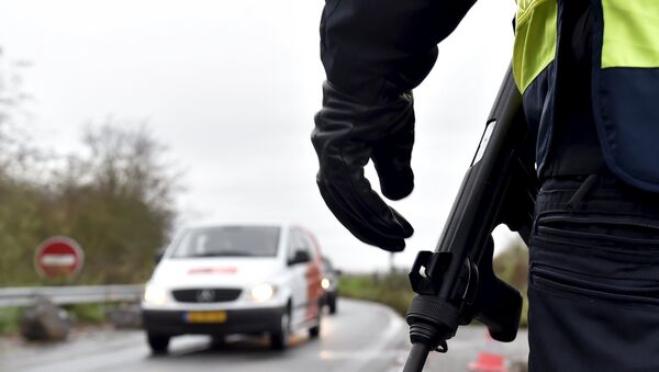A French police officer provides security as they control the crossing of vehicles on the border - Sputnik Afrique