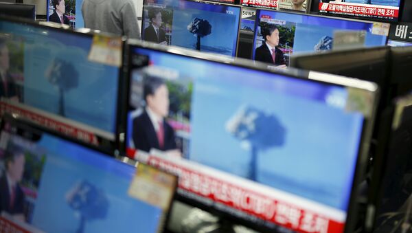 A sales assistant watches TV sets broadcasting a news report on North Korea's nuclear test, in Seoul, January 6, 2016 - Sputnik Afrique