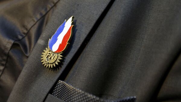 A supporter of French National Front political party holds a FN pin as he waits for French National Front political party leader and candidate Marine Le Pen results in the Nord-Pas-de-Calais-Picardie region, in the second-round regional elections in Henin-Beaumont, France, December 13, 2015 - Sputnik Afrique