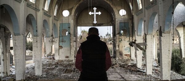 Un chrétien syrien prie dans l'église de Saint-Georges, détruite par l'EI (Daech) - Sputnik Afrique