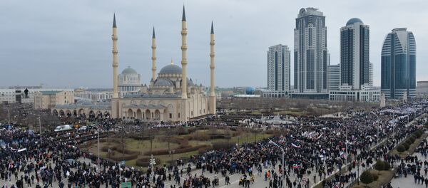 Des gens avec des pancartes et des drapeaux se sont massés devant la mosquée Akhmad Kadyrov, l'un des principaux édifices islamiques à Grozny, la capitale tchétchène - Sputnik Afrique