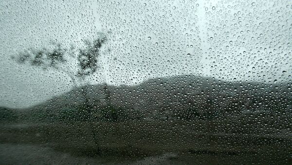 Un paysage est vu à travers une fenêtre humide de l'intérieur d'une voiture à Lima - Sputnik Afrique