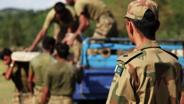 Local Pakistani Army Soldiers unload bags of concrete from a truck in Khyber - Pakhtunkhwa, Pakistan - Sputnik Afrique