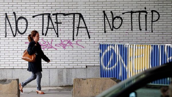 A pedestrian walks past graffiti that reads, No TAFTA, No TTIP, in Brussels, Belgium, July 27, 2015. - Sputnik Afrique