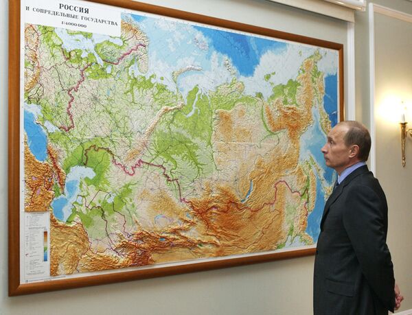 Le président russe Vladimir Poutine regarde une carte de la Russie dans sa résidence de Novo-Ogarevo - Sputnik Afrique