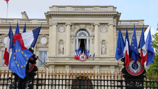 A worker arranges European flags alongside French national flags on the railings outside the Ministry of Foreign Affairs in Paris on May 9, 2015 as part of events marking Europe Day. - Sputnik Afrique