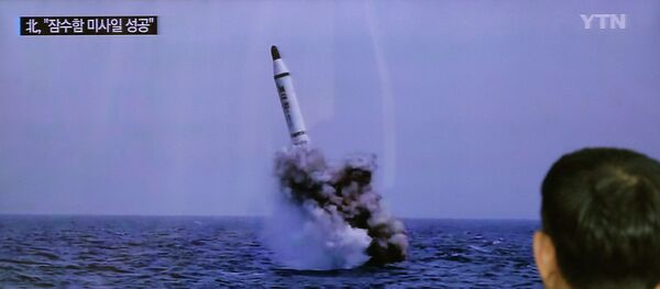 A South Korean man watches a TV news program showing an image published in North Korea's Rodong Sinmun newspaper of North Korea's ballistic missile believed to have been launched from underwater, at Seoul Railway station in Seoul, South Korea, Saturday, May 9, 2015 - Sputnik Afrique