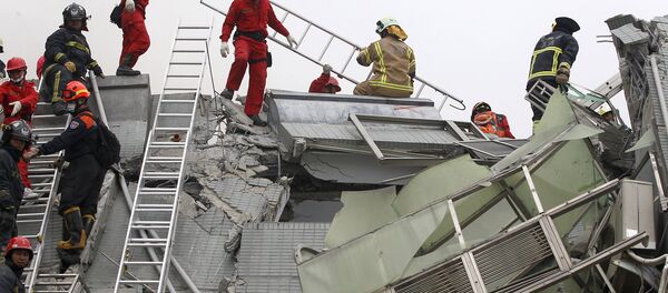Rescue personnel work at the site where a 17-storey apartment building collapsed in an earthquake in Tainan, southern Taiwan, February 6, 2016 - Sputnik Afrique