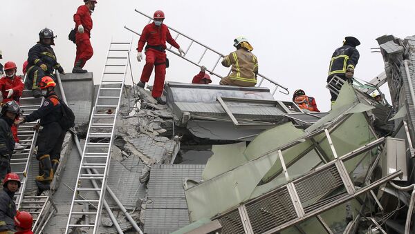 Rescue personnel work at the site where a 17-storey apartment building collapsed in an earthquake in Tainan, southern Taiwan, February 6, 2016 - Sputnik Afrique