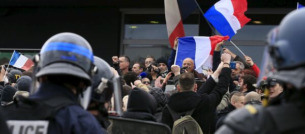 Les manifestants contre les migrants crient des slogans tandis que le général en retraite français Christian Piquemal fait un discours lors d'une manifestation organisée par le groupe PEGIDA, à Calais, France - Sputnik Afrique