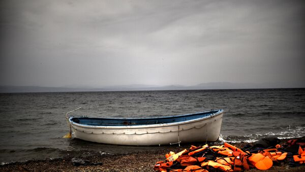 Life jackets and a boat that were used by refugees and migrants to cross the Aegean sea from Turkey lie abandoned on a beach on the Greek Island of Lesbos on October 8, 2015. - Sputnik Afrique