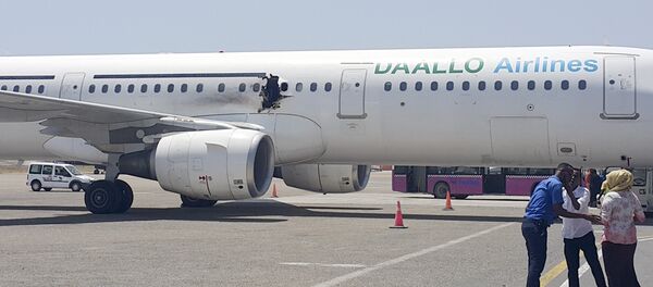 A hole is seen in a plane operated by Daallo Airlines as it sits on the runway of the airport in Mogadishu, Somalia - Sputnik Afrique