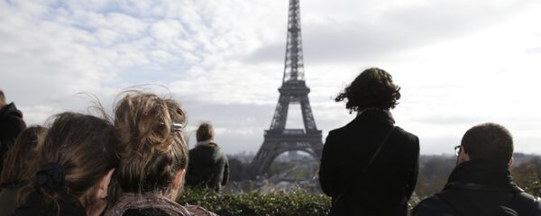 People observe in front of the Eiffel tower a minute of silence at the Place de Trocadero in Paris on November 16, 2015 to pay tribute to victims of the attacks claimed by Islamic State which killed at least 129 people and left more than 350 injured on November 13. - Sputnik Afrique