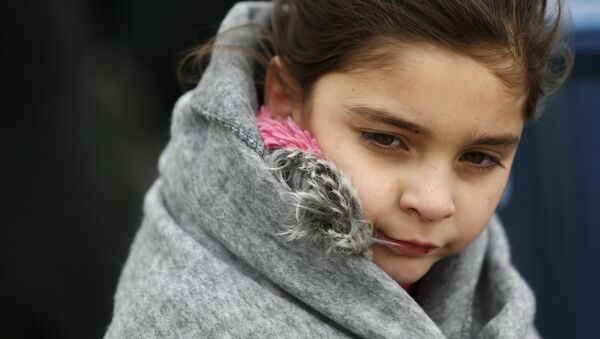 A migrant girl is covered with a blanket moments after refugees and migrants arrived on a raft on a beach on the the Greek island of Lesbos, January 29, 2016. - Sputnik Afrique