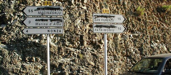 Panneaux de signalisation bilingues, avec les noms (IGN) rayés par les nationalistes locaux. - Sputnik Afrique