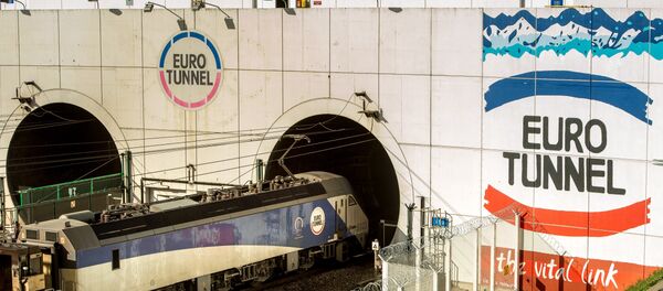 This photo taken on October 20, 2015 in Coquelles shows a Eurotunnel train entering into a new freight tunnel created to increase cross-English Channel trading of goods while maintaining security against increased illegal migrant activities. - Sputnik Afrique