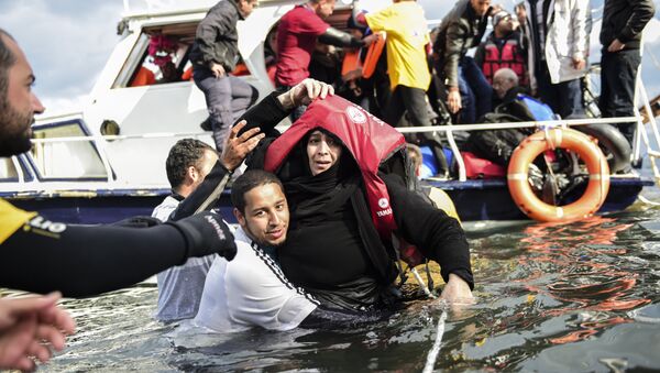 Migrant families - helped by rescuers - disembark on the Greek island of Lesbos after crossing with other migrants and refugees the Aegean Sea from Turkey, on November 25, 2015. - Sputnik Afrique
