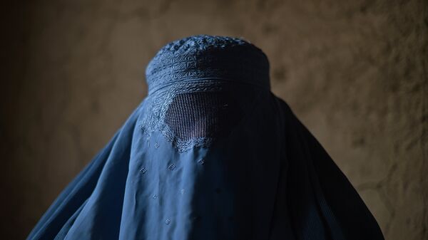 An internally displaced Afghan woman waits to receive food relief aid from the World Food Programme (WFP) in Kabul on January 13, 2015. - Sputnik Afrique