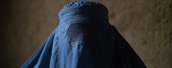 An internally displaced Afghan woman waits to receive food relief aid from the World Food Programme (WFP) in Kabul on January 13, 2015. - Sputnik Afrique