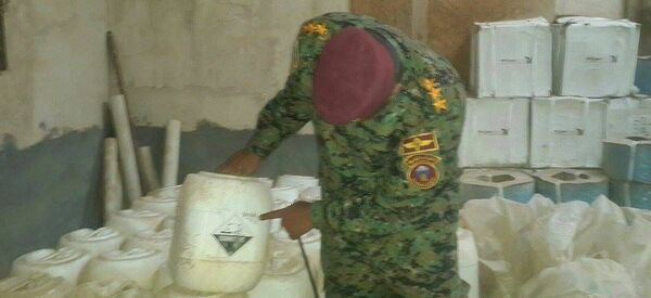 Un des officiers irakiens montre du doigt des bidons avec des substances dangereuses pour l'homme - Sputnik Afrique