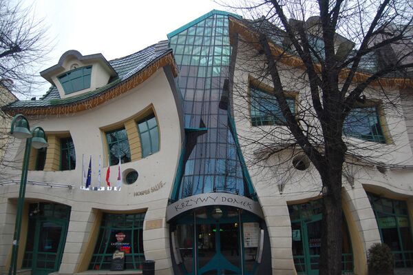 La maison tordue se situe à Sopot en Pologne, elle ne comporte aucun angle droit. Les murs, les fenêtres et les portes se contorsionnent comme si on regardait à travers un verre déformant. C'est aujourd'hui un centre commercial. - Sputnik Afrique