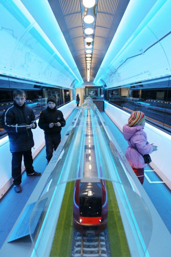 Les habitants de nombreuses villes russes auront la possibilité de voir l'exposition mobile de RZD. Sur la photo: les visiteurs regardent la maquette du train «Lastotchka» (Hirondelle). - Sputnik Afrique
