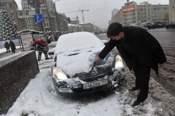 Sur la photo: un automobiliste nettoie sa voiture sur la place Smolenskaïa à Moscou. - Sputnik Afrique