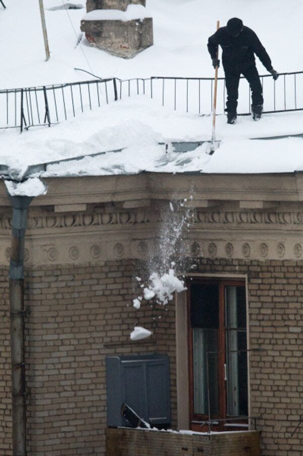 Sur la photo: un concierge nettoie le toit de la neige. - Sputnik Afrique