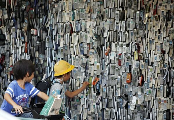 Sur la photo : les enfants regardent un mur avec des téléphones mobiles usagés sur un marché chinois - Sputnik Afrique