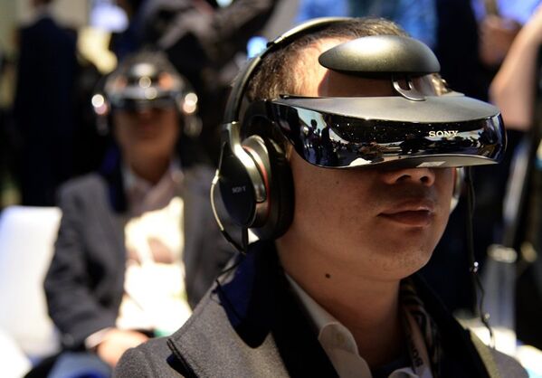 Un visiteur essaie le nouveau casque de réalité virtuelle présenté par Sony au Consumer Electronics Show 2014 de Las Vegas. - Sputnik Afrique