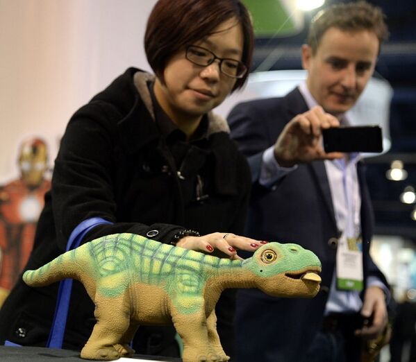 Les visiteurs du Consumer Electronics Show 2014 découvrent les nouveaux jouets robotisés en forme de dinosaure. - Sputnik Afrique