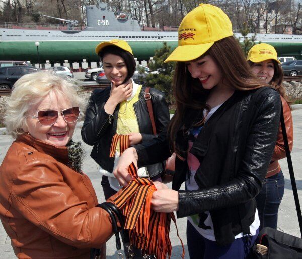 Sur la photo : des bénévoles distribuent des rubans de Saint-Georges sur le quai Korabelnaïa à Vladivostok. - Sputnik Afrique