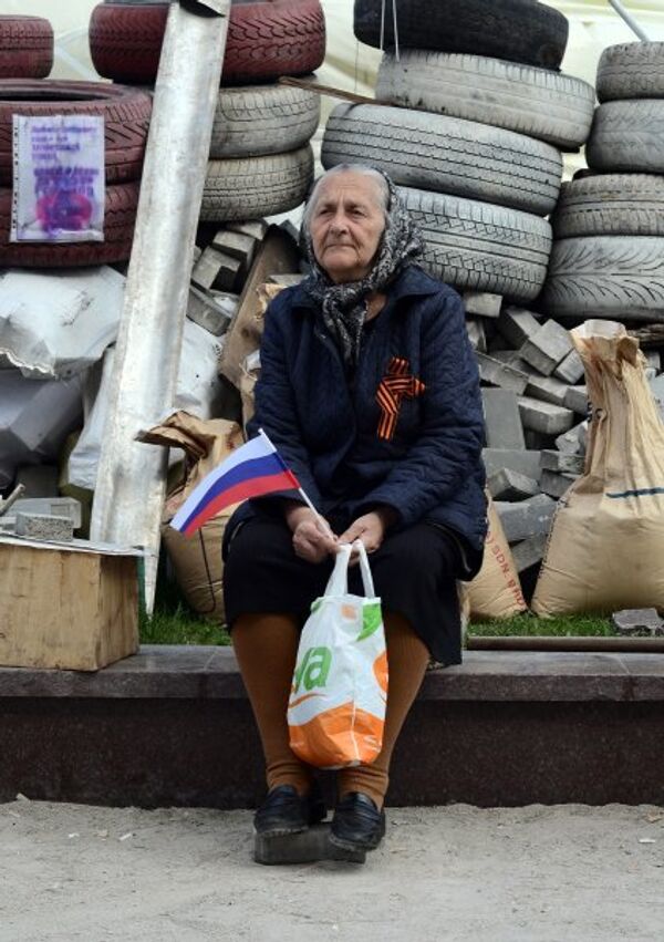 Photo : une partisane de la fédéralisation de l'Ukraine portant un ruban de Saint-Georges sur la place devant le bâtiment de l’administration de la région de Donetsk. - Sputnik Afrique