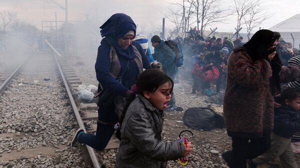 Migrants and refugees run away from tear-gas and stun grenades after Macedonian police fired tear gas at hundreds of Iraqi and Syrian migrants who tried to break through the Greek border fence in Idomeni, on February 29, 2016. - Sputnik Afrique