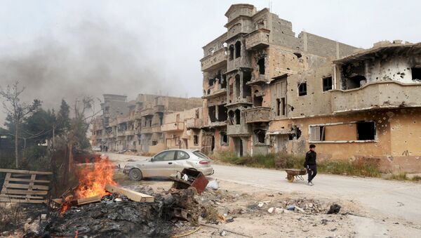 A man pulls a wheelbarrow past destroyed buildings after clashes between military forces loyal to Libya's eastern government and Islamist fighters, in Benghazi, Libya, February 28, 2016. - Sputnik Afrique