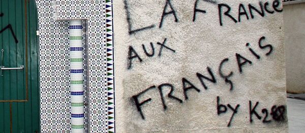Photo taken on December 13, 2009 shows the entrance to the Castres mosque which was desecrated overnight. Xenophobic neo-nazi propos were spray-painted on the wall, pigs trotters hung from the door handle and pigs ears stapled to the door. Graffiti at right reads, France for the French. - Sputnik Afrique