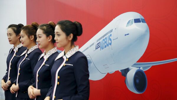 Staff members stand in front of a wall bearing the image of the Airbus A330 plane at a ground-breaking ceremony for the Airbus A330 completion and delivery center in Tianjin, China, March 2, 2016. - Sputnik Afrique