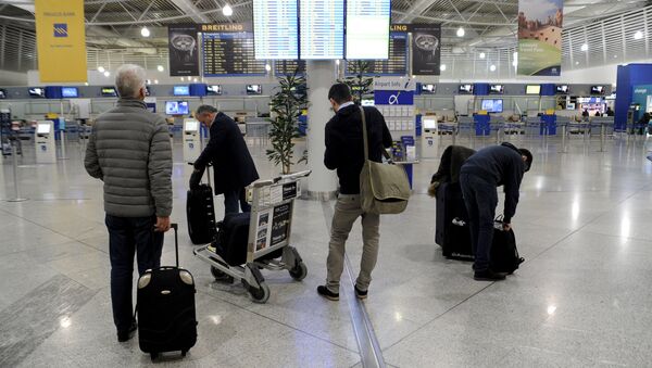 Passengers look at an announcement board inside the Athens Eleftherios Venizelos International Airport, as flight controllers hold a work stoppage during a 24-hour general strike against planned pension reforms in Athens, Greece, February 4, 2016. - Sputnik Afrique