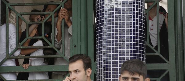 Migrants attendent à l'arrêt de bus à Istanbul - Sputnik Afrique