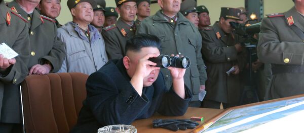 North Korean leader Kim Jong Un uses a pair of binoculars to watch live ammunition firing drills. - Sputnik Afrique